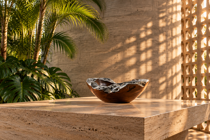 Bowl de madera de teca sobre mesa de travertino en interior de hormigón