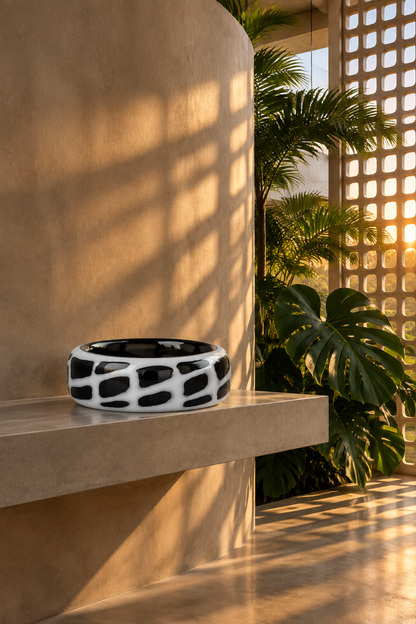 Bowl Zoe sobre repisa de hormigón en muro curvo con plantas tropicales