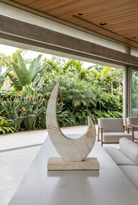 Escultura Clemente en un living abierto a un jardín tropical