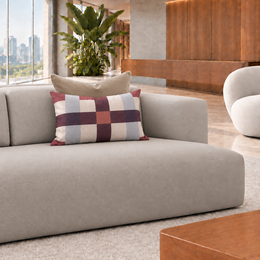 Cojín rectangular de cuadros burdeos de 60 x 40 cm con cojín café detrás en un living contemporáneo luminoso