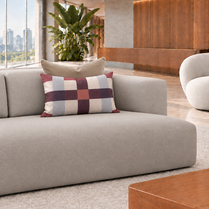 Cojín rectangular de cuadros burdeos de 60 x 40 cm con cojín café detrás en un living contemporáneo luminoso