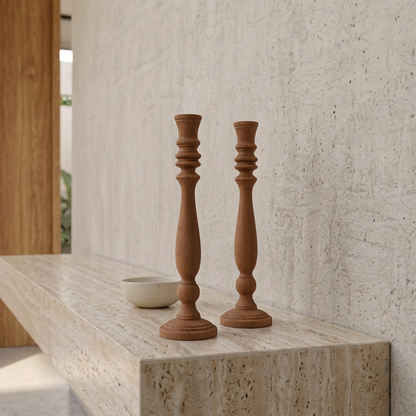 Par de candelabros Fabio del mismo tamaño sobre consola de travertino, en un encuadre cerrado con muro claro y madera.