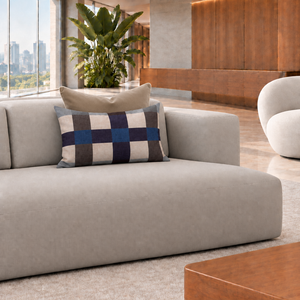 Cojín rectangular de cuadros azul de 60 x 40 cm con cojín café detrás en un living contemporáneo luminoso